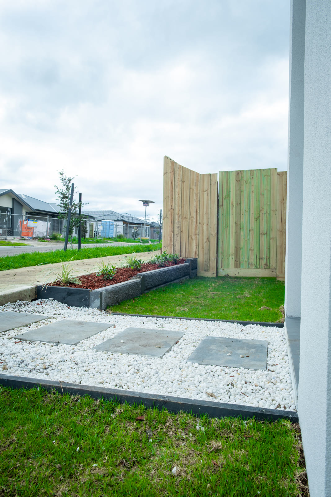 Backyard lawn with paved path and timber gate